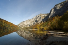 Reflections in Leopoldsteinersee in autumn moonlight with stars